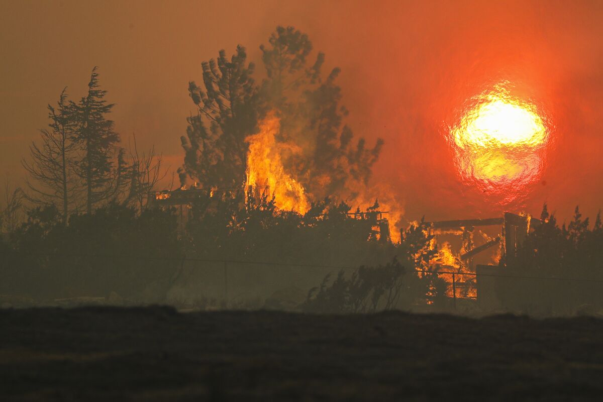 A house on Cima Mesa Road in Juniper Hills burns in the Bobcat fire.