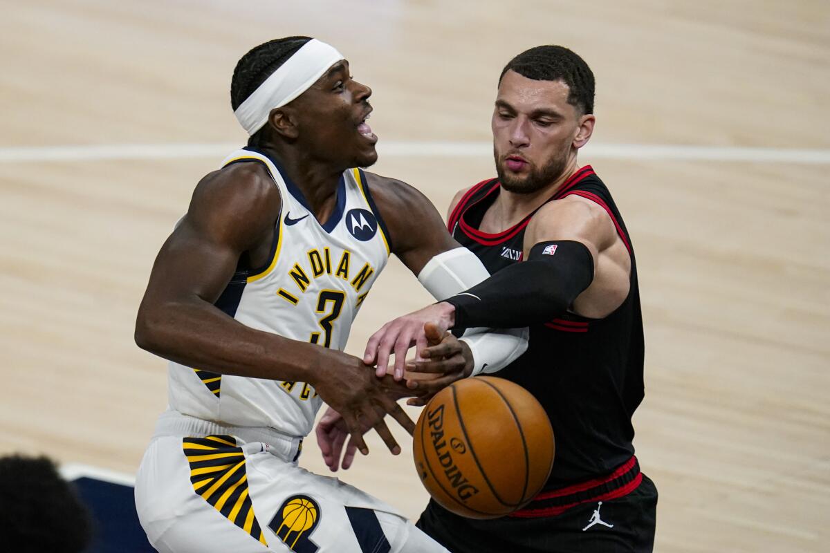 Indiana Pacers guard Aaron Holiday (3) is fouled by Chicago Bulls guard Zach LaVine during the first half of an NBA basketball game in Indianapolis, Tuesday, April 6, 2021. (AP Photo/Michael Conroy)