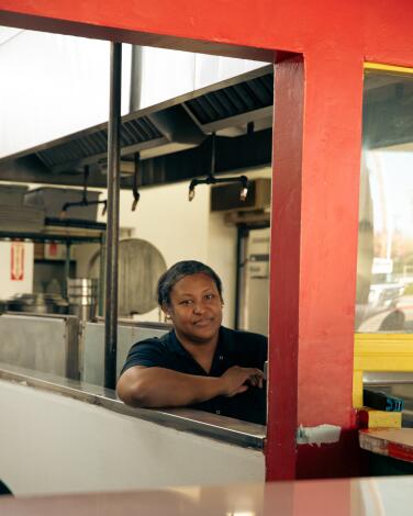 A person sits in a covered restaurant booth