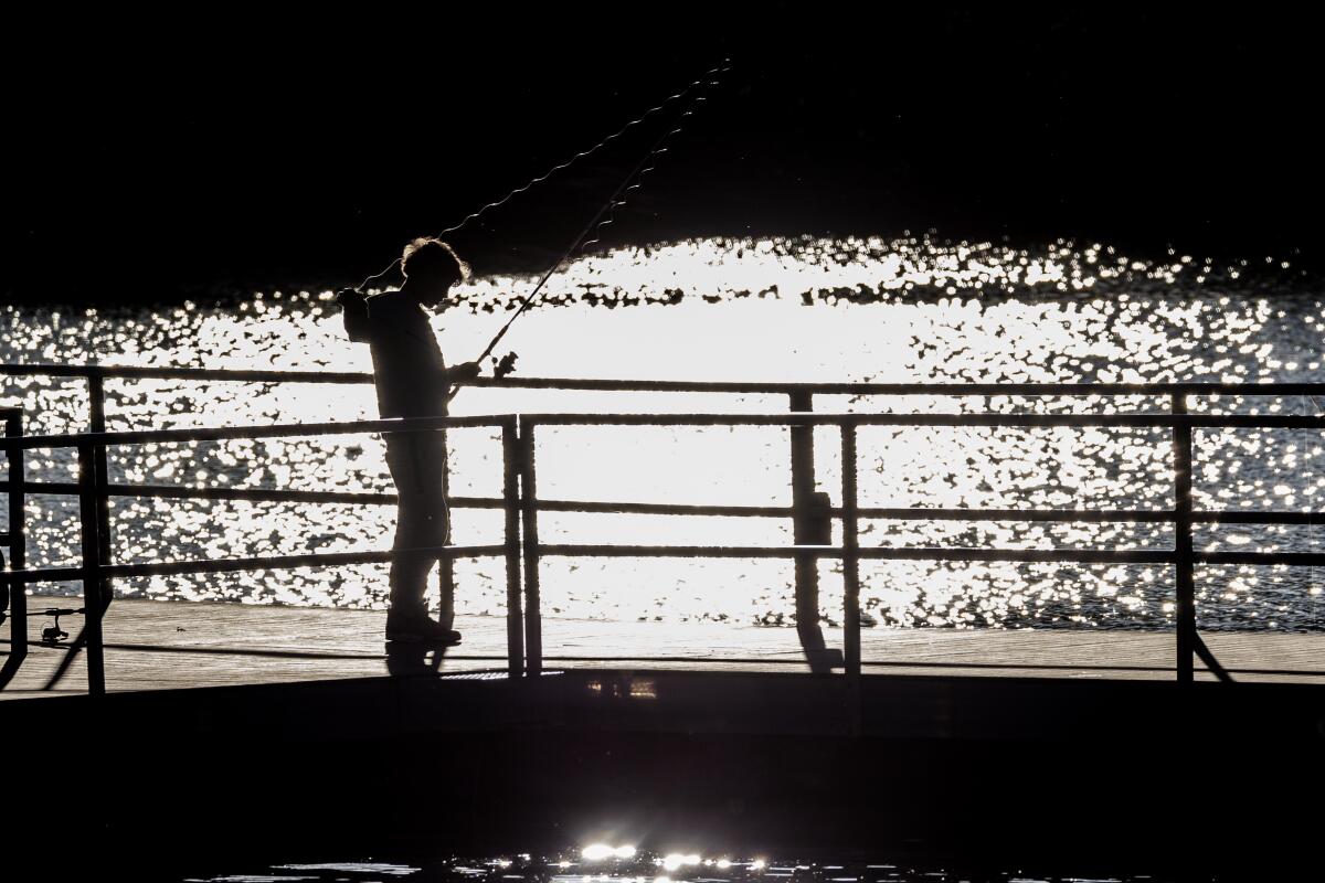 A youngster's fishing line glistens against Big Bear Lake in the late afternoon at Boulder Bay Park.