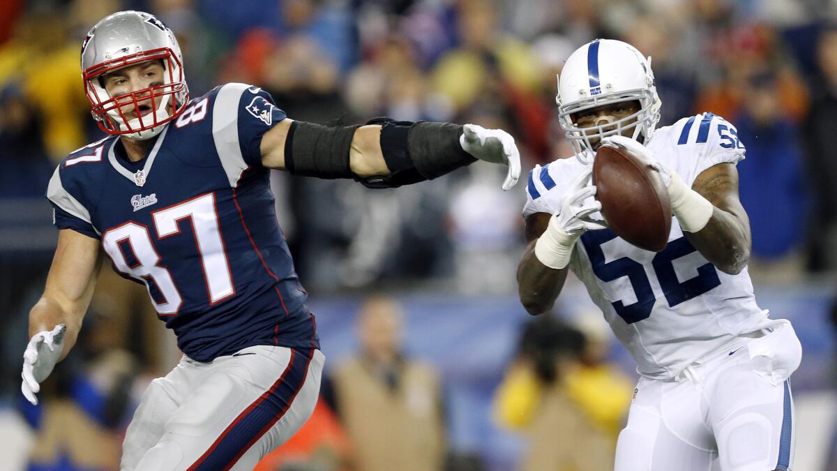 Indianapolis Colts inside linebacker D'Qwell Jackson, right, intercepts a pass intended for New England Patriots tight end Rob Gronkowski during the second quarter of the Patriots' 45-7 win in the AFC Championship game Sunday.