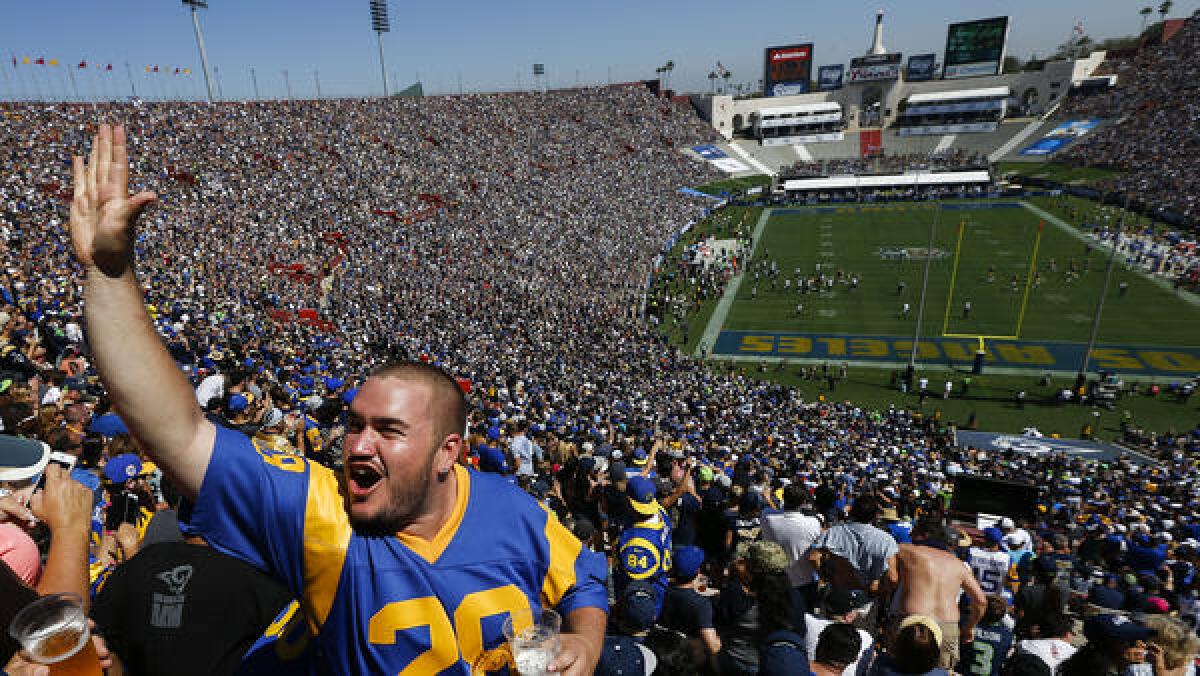 Fans celebrate during the Rams' first home opener in L.A. since 1994 on Sunday at the Coliseum. Click the image for more photos.