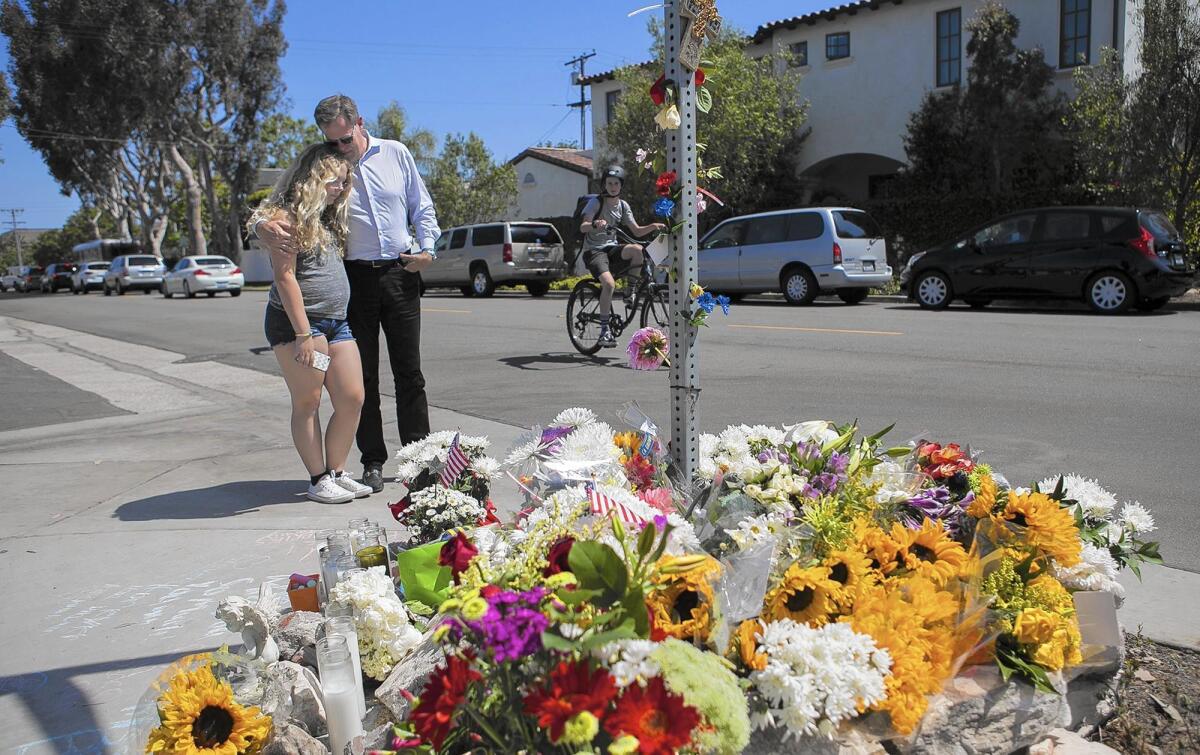 Kent Barkouras and daughter Sara visit a memorial at 15th Street and Michael Place in Newport Beach on May 26, 2016, the day after Brock McCann, 8, was struck and killed there by a trash truck.