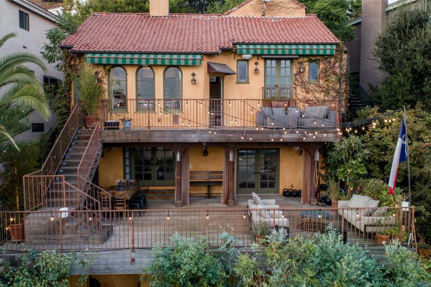 Built in 1925, the hillside home includes two decks, a loggia and a tropical backyard with a bridge, koi pond and fire pit.