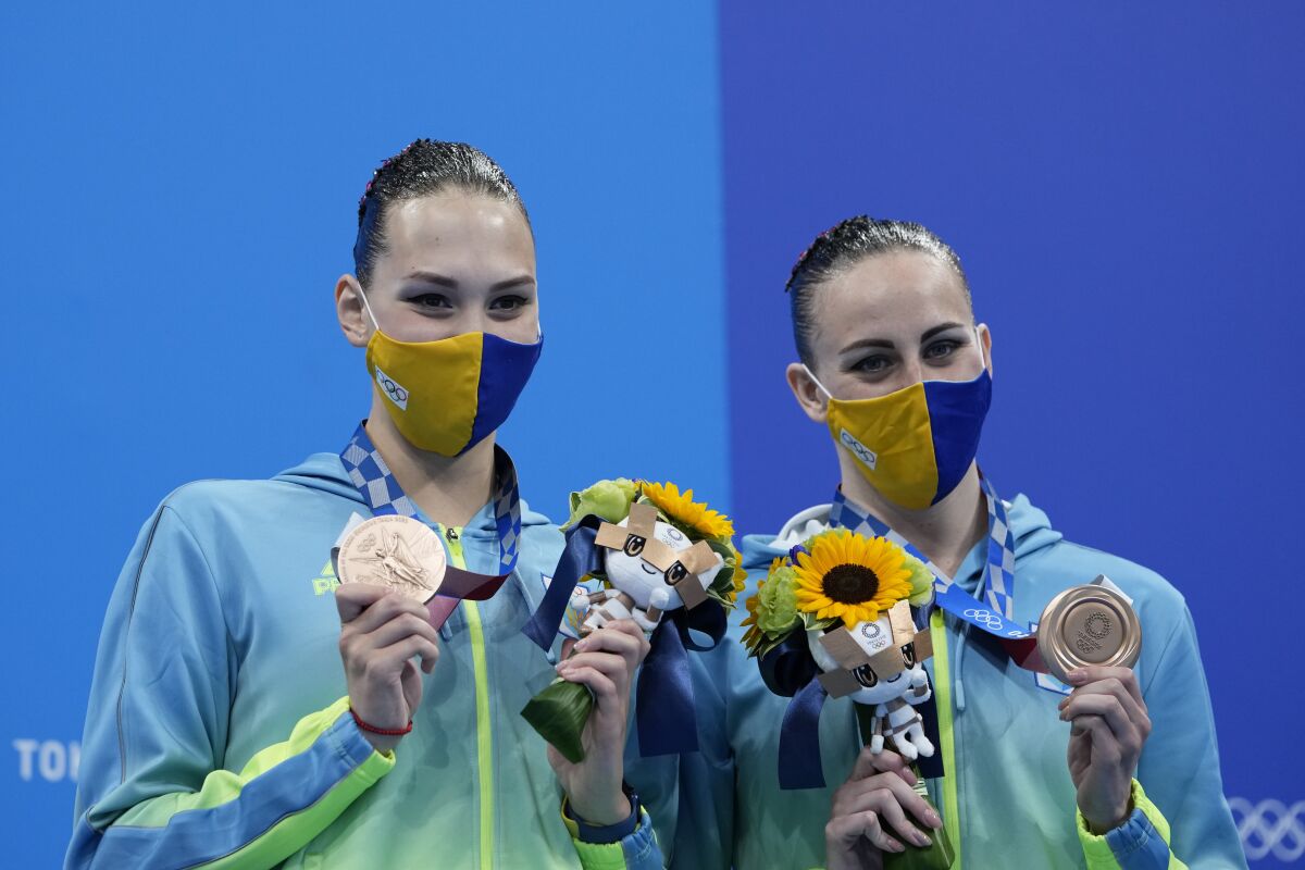 Marta Fiedina and Anastasiya Savchuk of Ukraine shows their medals during the medal ceremony of the duet free routine final at the the 2020 Summer Olympics, Wednesday, Aug. 4, 2021, in Tokyo, Japan. (AP Photo/Alessandra Tarantino)