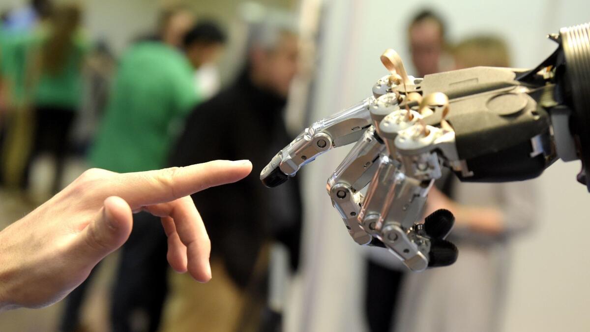 An automated hand made by the Germany company Schunk reaches out to an old-fashioned model during an international robotics conference in Madrid in 2014.