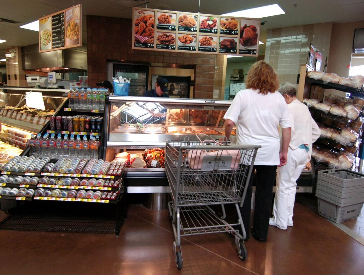 Customers shop in the deli at a Wal-Mart store in Rogers, Ark., on June 5, 2008.
