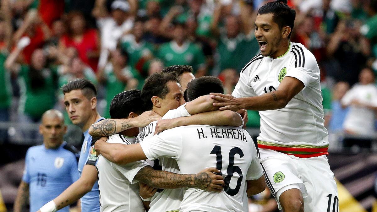 Mexico's Hector Herrera (16) celebrates his goal against Uruguay with teammates, including Jesus Manuel Corona (10), on Sunday.