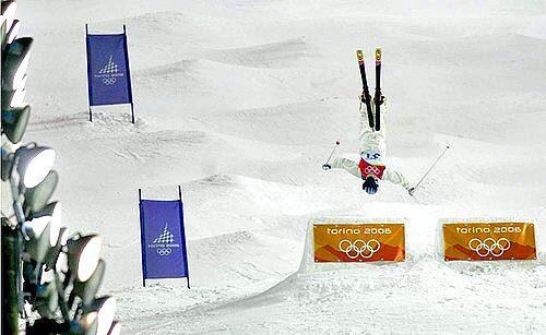 Tae Satoya of Japan flips over the first jump on the lighted course in Freestyle Skiing Ladies Moguls Finals.