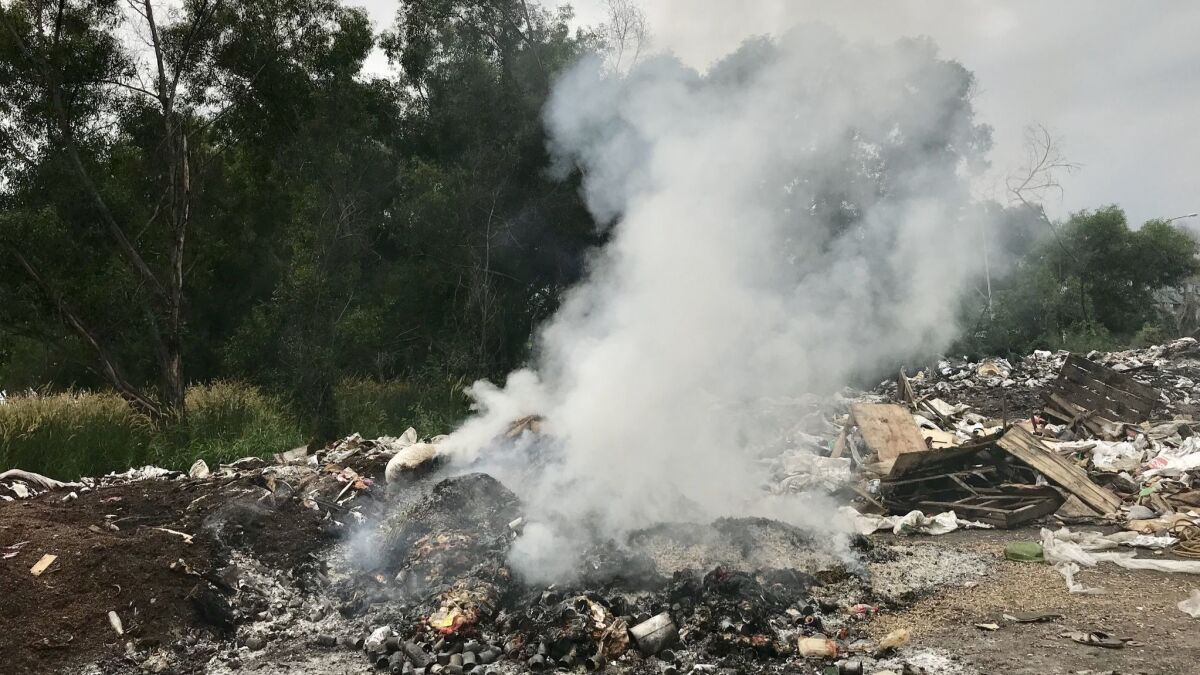 A fire burns at an illegal dumpsite in Port Klang, Malaysia.