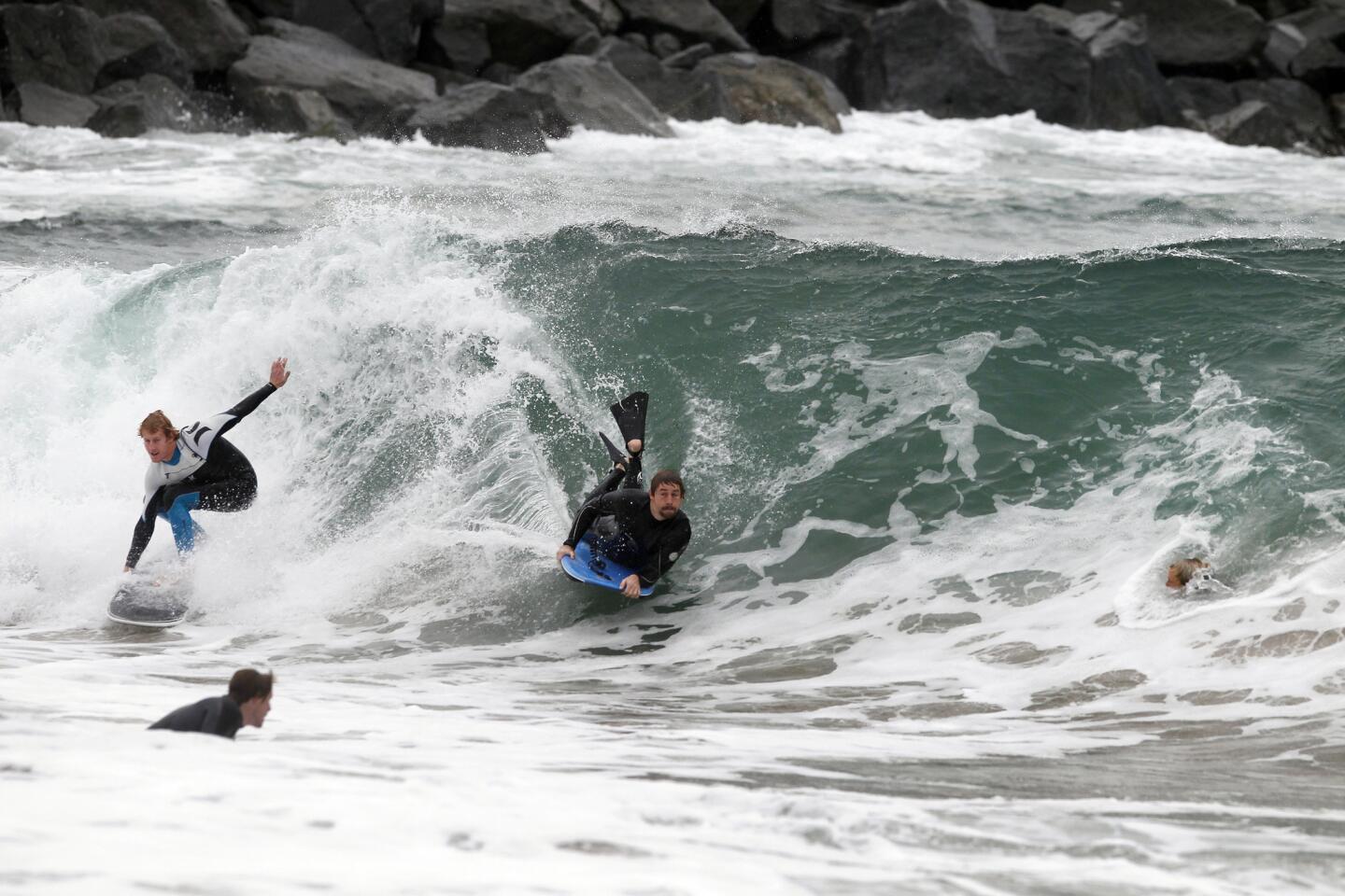 A surfer, bodyboarder and bodysurfer compete to ride a big wave at the Wedge in Newport Beach.