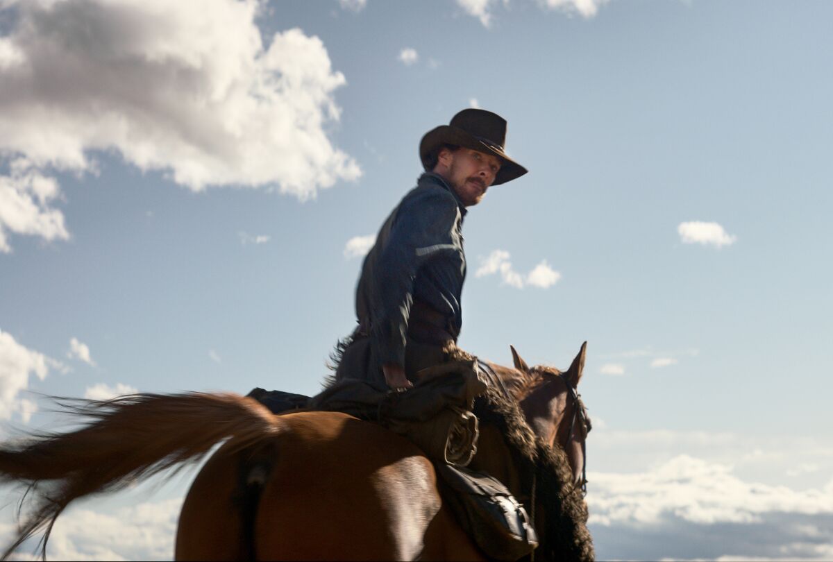 مردی با کلاه گاوچرانی سوار بر اسب در حالی که به عقب نگاه می کند.