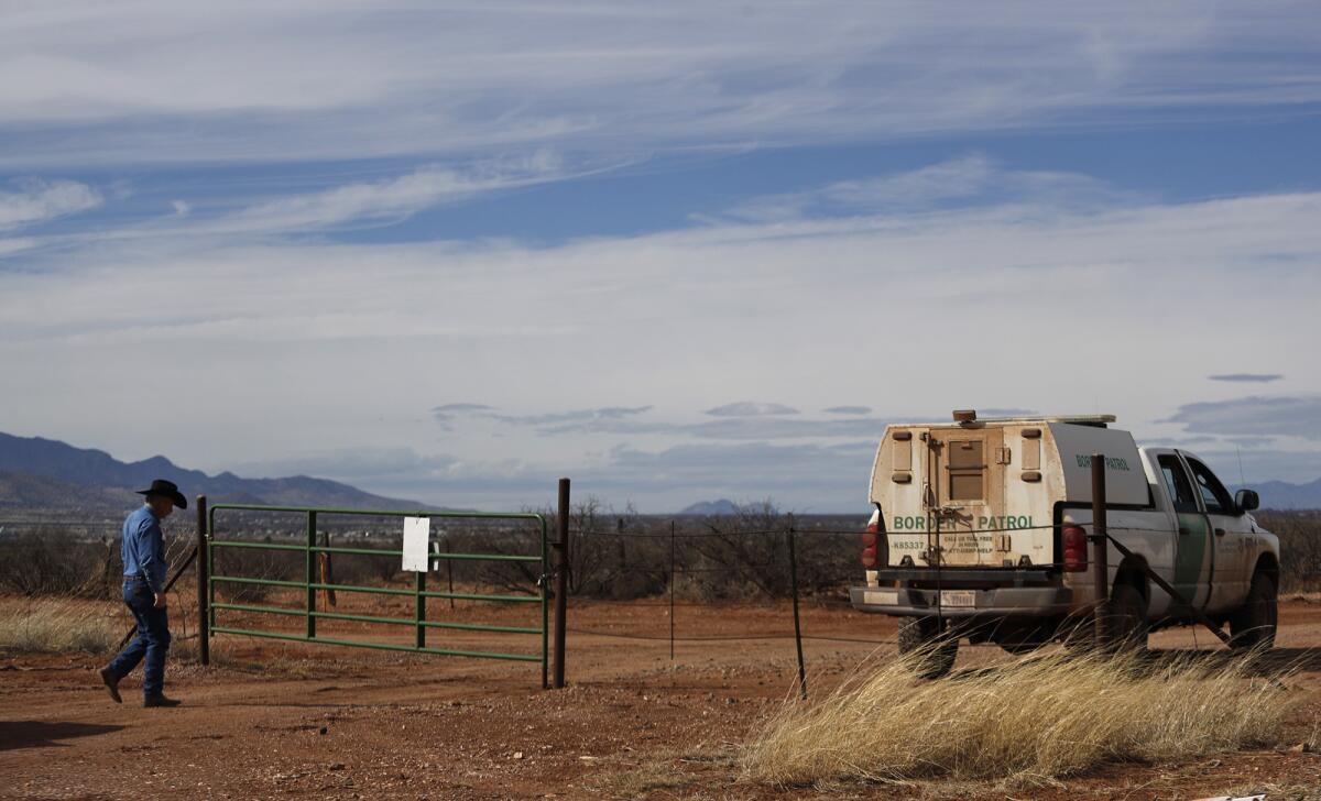 John Ladd walks to open a gate on his ranch where a Border Patrol agent is stationed.
