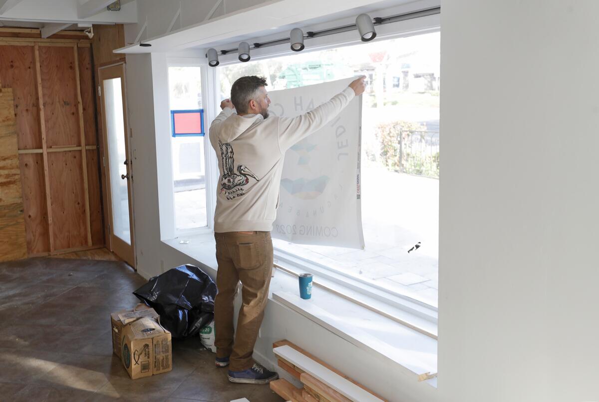 Steve Munsey posts a sign in the space that will be Jedidiah Coffee in North Laguna.