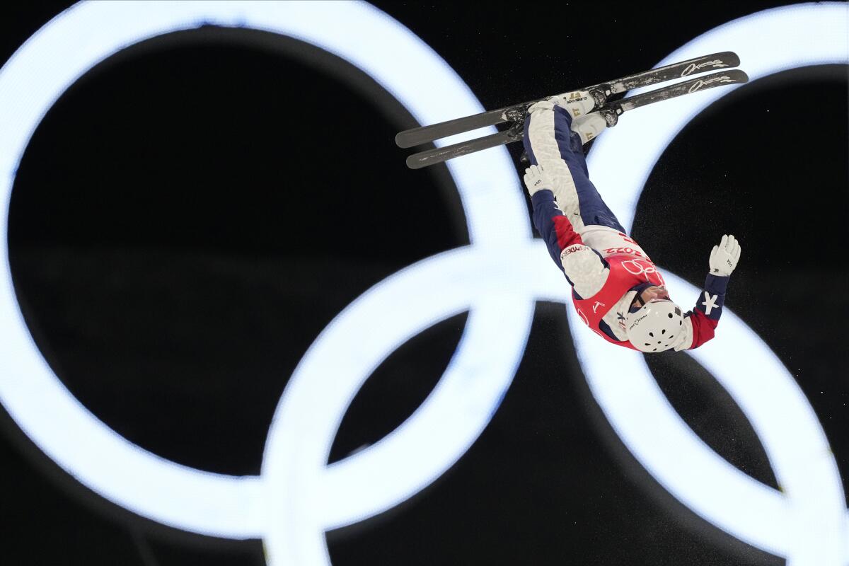 Justin Schoenefeld flies upside down in front of the Olympic rings during the aerial finals.