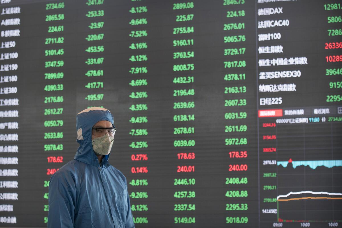 A worker stands near an electronic display board in the lobby of the Shanghai Stock Exchange building on Monday.