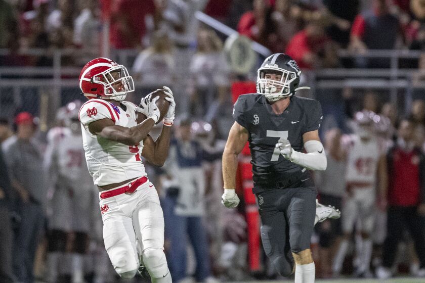 BELLFLOWER, CALIF. -- FRIDAY, OCTOBER 25, 2019: St. John Bosco free safety Jake Newman, right, watches as Mater Dei wide receiver Kody Epps hauls in a pass during the first quarter at St. John Bosco High School in Bellflower, Calif., on Oct. 25, 2019. (Allen J. Schaben / Los Angeles Times)