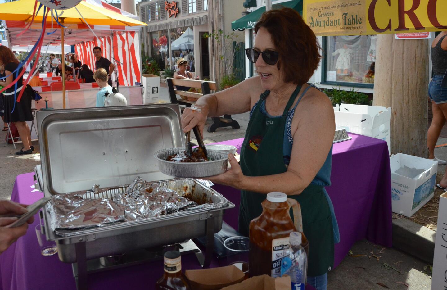 Victoria DeFrenza of Crocker's serves baby back ribs during Sunday's Balboa Island Carnival & Taste of the Island on Marine Avenue.