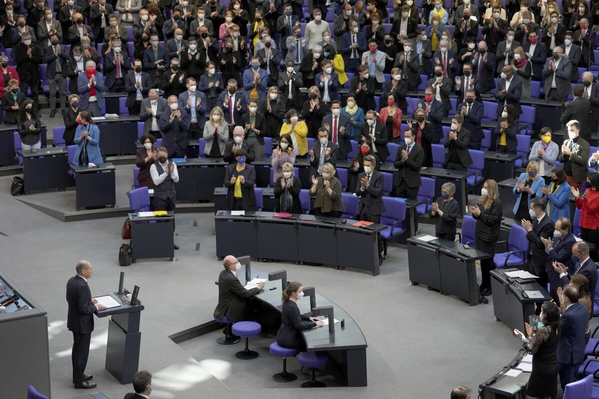 Members of parliament in rows applaud German Chancellor Olaf Scholz