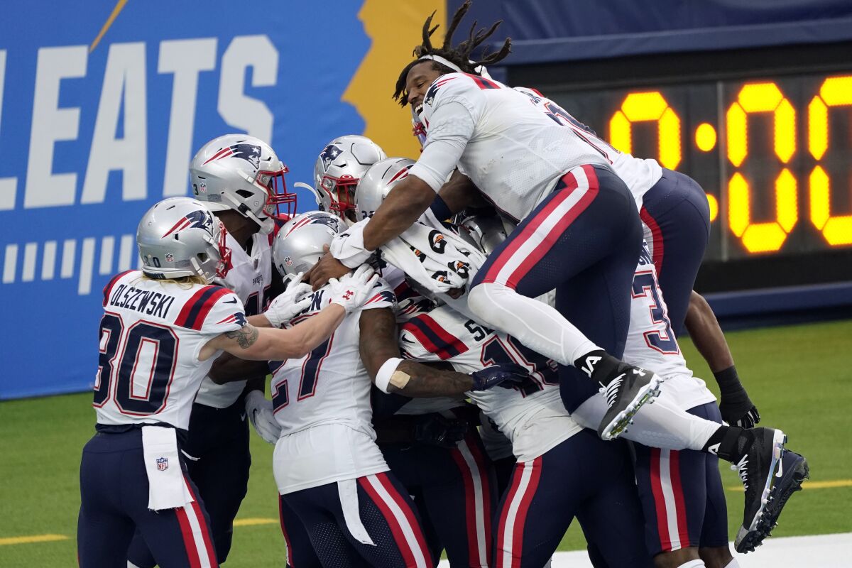 The New England Patriots celebrate after Devin McCourty returned a block field goal attempt for a touchdown during the first half of an NFL football game against the Los Angeles Chargers Sunday, Dec. 6, 2020, in Inglewood, Calif. (AP Photo/Ashley Landis)