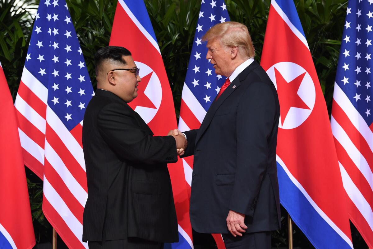 North Korean leader Kim Jong Un shakes hands with President Trump at the start of their summit in Singapore on June 12, 2018.