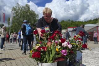 Una persona deposita flores en el exterior del hospital universitario F. D. Roosevelt, donde el primer ministro eslovaco, Robert Fico, estaba siendo tratado tras recibir varios disparos, en Banska Bystrica, en el centro de Eslovaquia, el 18 de mayo de 2024. (AP Foto/Lefteris Pitarakis)