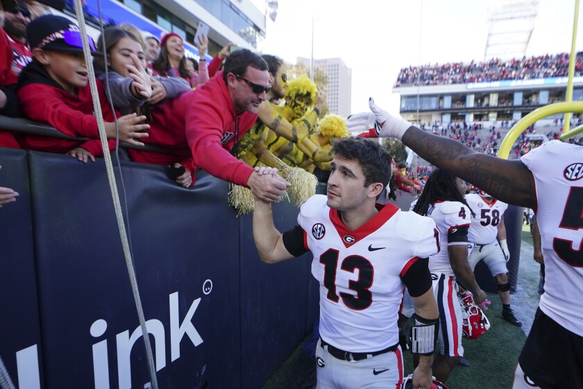 Georgia quarterback Stetson Bennett (13) celebrates with fans after the Bulldogs defeated Georgia Tech on Nov. 27, 2021.