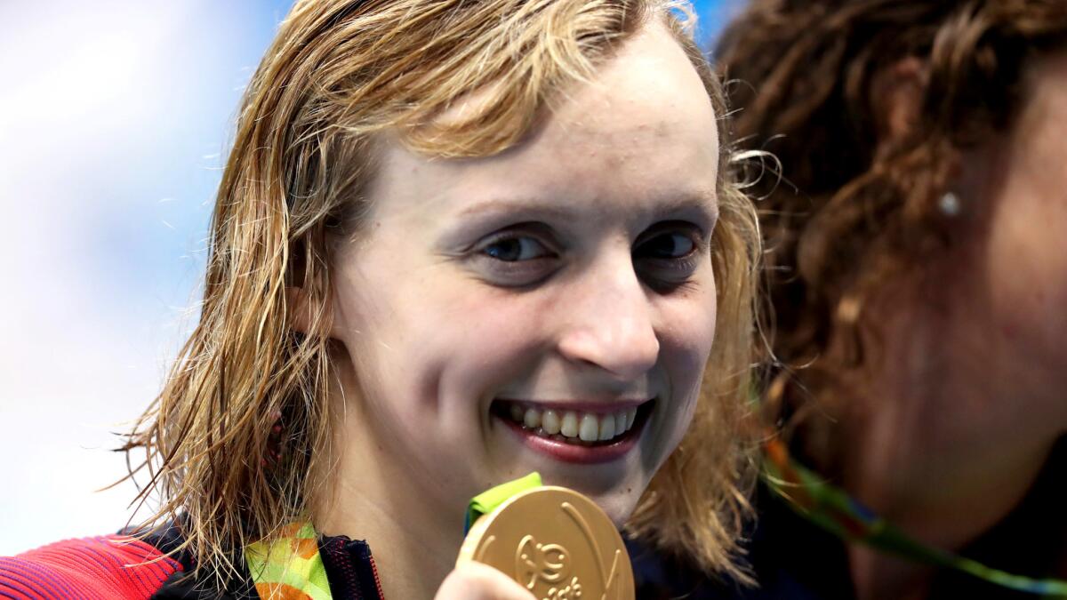 Katie Ledecky is all smiles after winning gold with her teammates in the 800-meter freestyle relay.