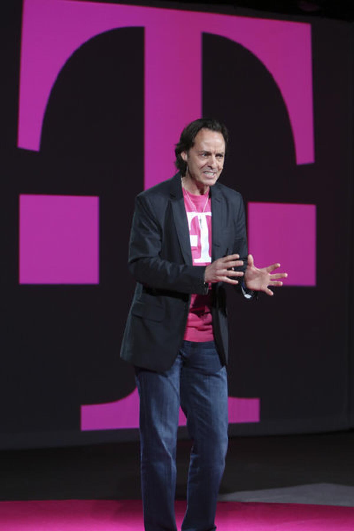 T-Mobile CEO John Legere gestures as he speaks during a news conference in March at which T-Mobile announced it would start selling the iPhone 5. Legere has been pushing T-Mobile away from industry standards.