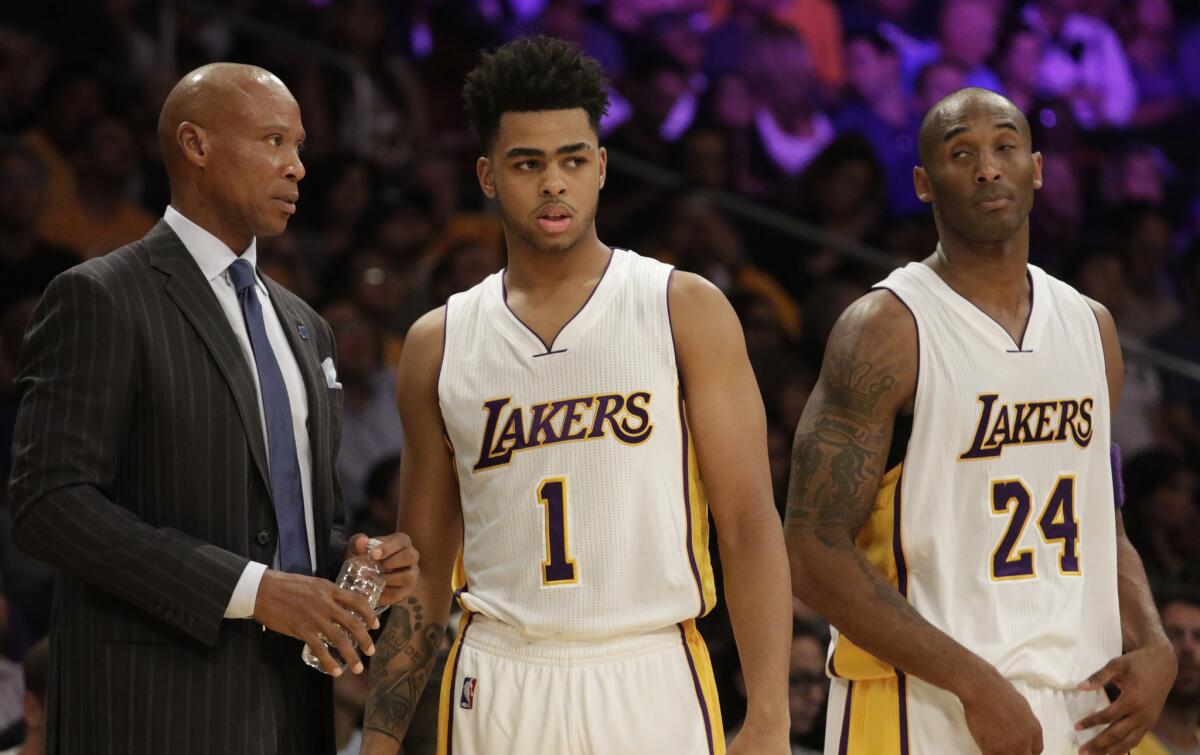 Lakers Coach Byron Scott chats with rookie guard D'Angelo Russell (1) as Kobe Bryant (24) listens during the first half of their game Sunday.