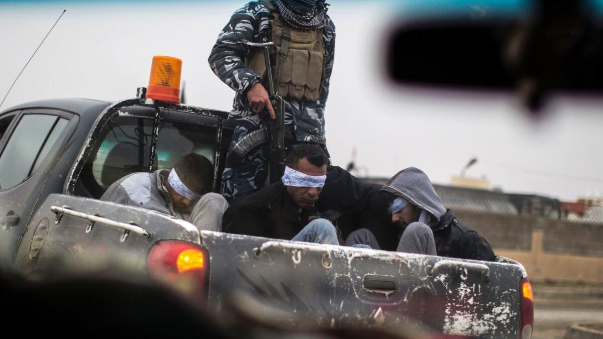 Christian militia fighters from the Nineveh Plain Protection Units transport four men, accused members of Islamic State, on Dec. 20.