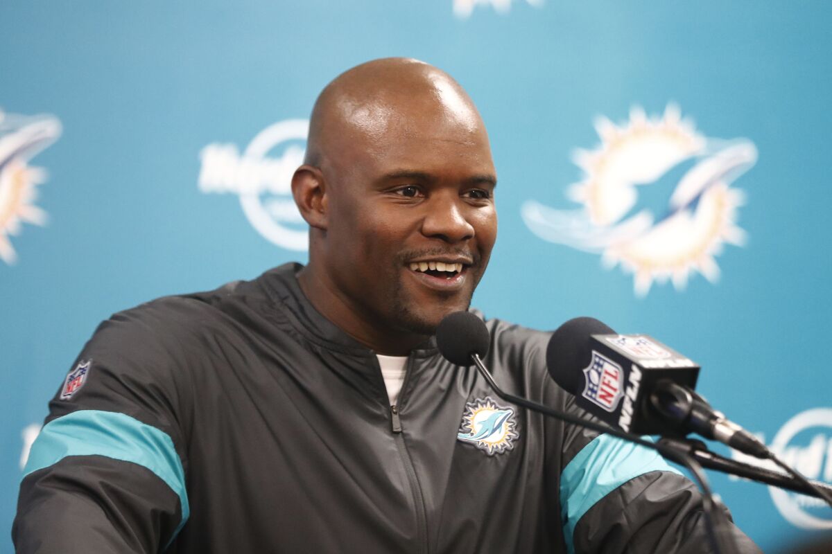 FILE - In this Dec. 22, 2019, file photo, Miami Dolphins head coach Brian Flores smiles during a news conference following an NFL football game against the Cincinnati Bengals in Miami Gardens, Fla. At least four Miami Dolphins rookies are expected to see significant action in Sunday’s, Sept. 12, 2020, opener. Flores allowed himself a slight smile when asked Wednesday, Sept. 9, 2020, how comfortable he was starting rookies in the season's first game.(AP Photo/Brynn Anderson, File)