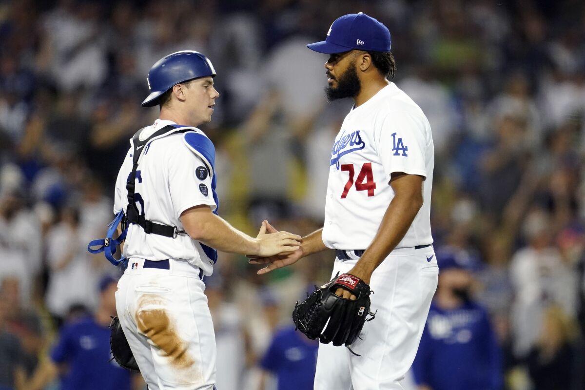 Dodgers catcher Will Smith shakes hands with closer Kenley Jansen after the team's 5-2 win over the Colorado Rockies.