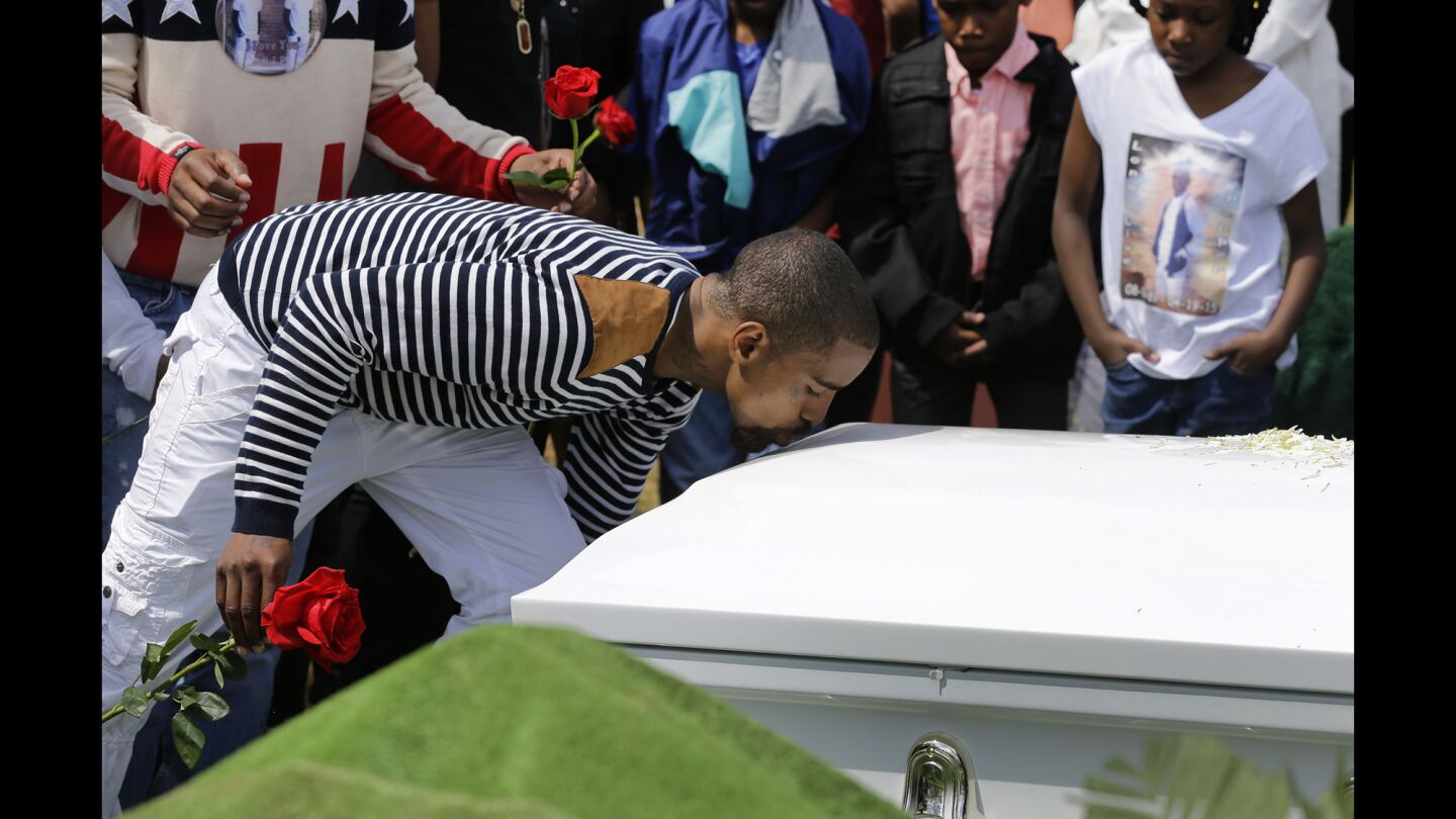 A mourner kisses Freddie Gray's casket before placing a rose on it at Gray's burial Monday in Baltimore.