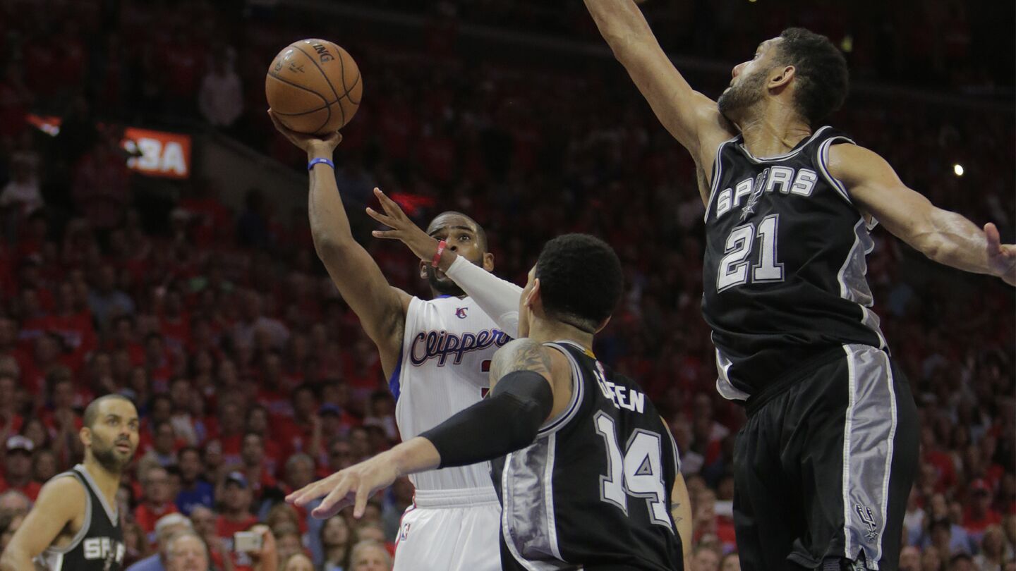 Clippers point guard Chris Paul, center, shoots the winning basket over San Antonio Spurs teammates Danny Green, center, and Tim Duncan during the Clippers' 111-109 victory in Game 7 of the Western Conference quarterfinals at Staples Center on May 2, 2015.