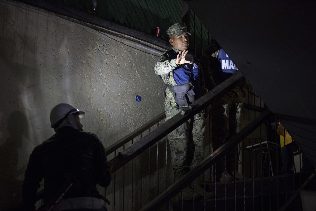 A Marine joins the rescue efforts at the Enrique Rebsamen school in Mexico City on Thursday night. (Anthony Vazquez / AP)