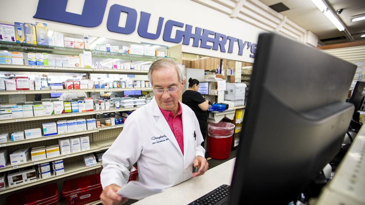 Pharmacist Jim Hawkins works behind the counter at Dougherty's Pharmacy in Dallas. Pharmacy managers and pharmacists had the second- and third-highest annual base pay, according to a Glassdoor report, at $146,412 and $127,120, respectively.