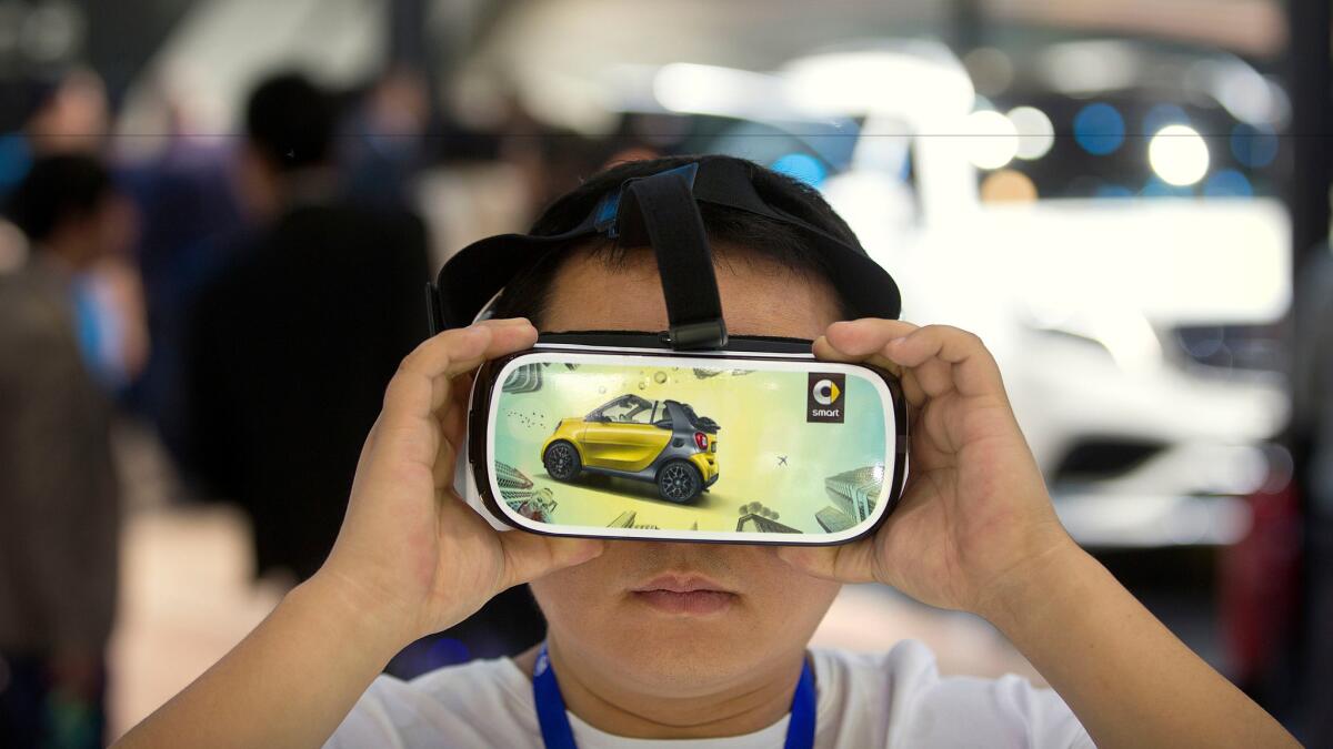 A visitor watches a virtual reality presentation in Beijing, April 26, 2016.