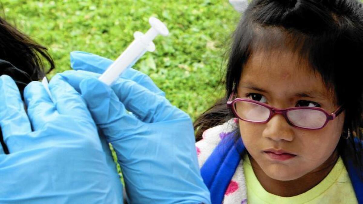 Los investigadores concluyeron que la protección del refuerzo de la vacuna Tdap contra la tos ferina se desvanece rápidamente. En la imagen, Debbie Gonzáles observa a su padre mientras éste recibe la dosis de refuerzo, en 2012.