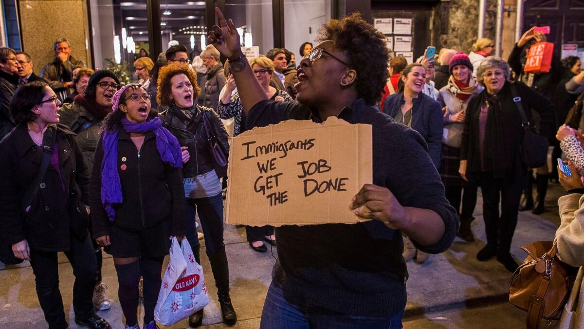 A protester holds a sign with lyrics from "Hamilton." She was part of a group shouting at Vice President-elect Mike Pence as he left the show Friday night.