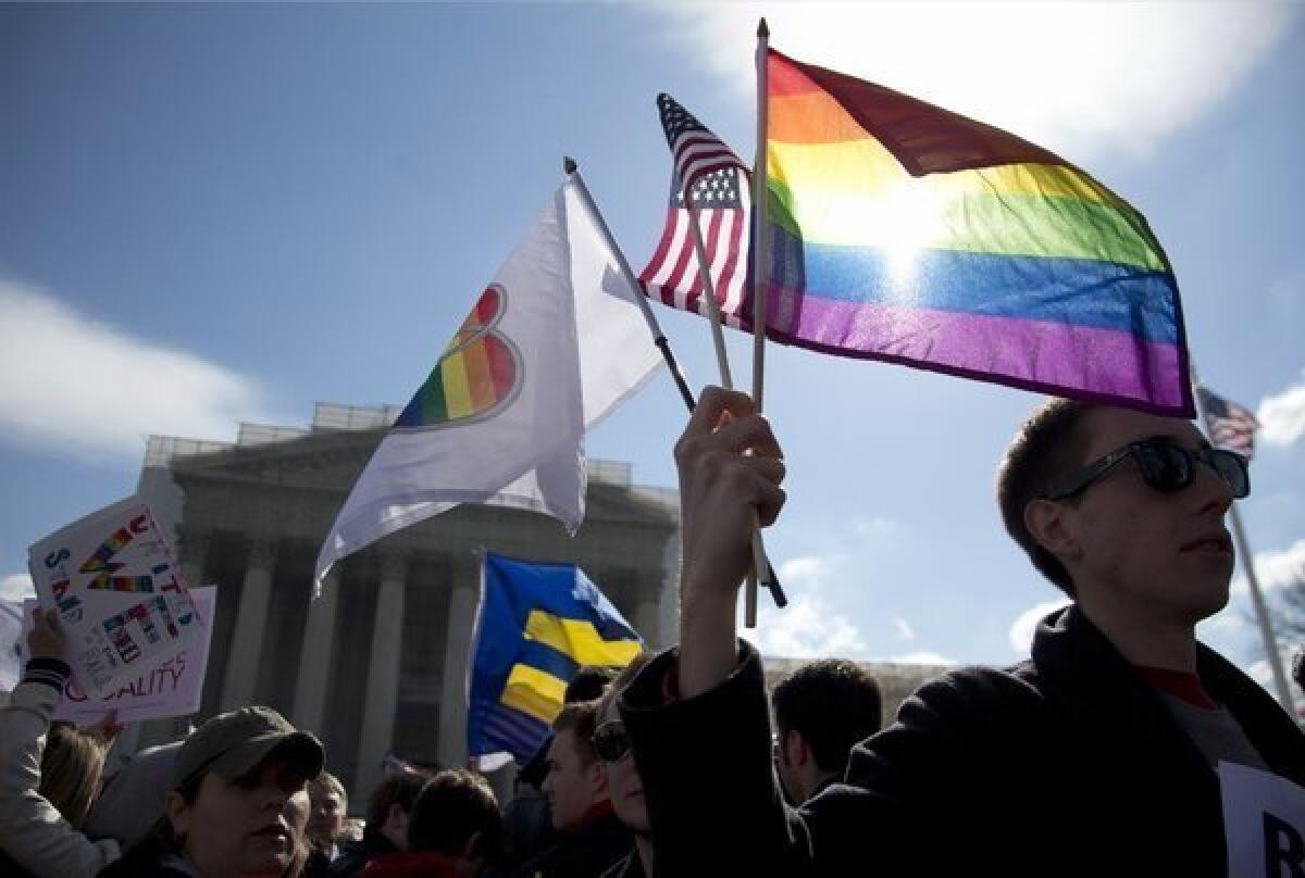 Kevin Coyne of Washington, D.C. holds flags in front of the Supreme Court on March 27.