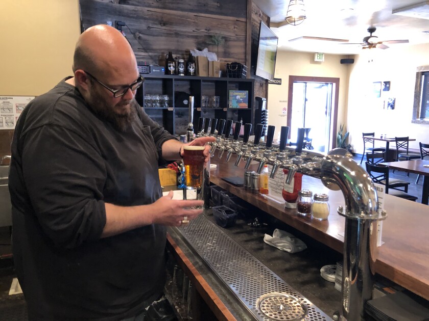 A man pouring beer from a tap at a brewery