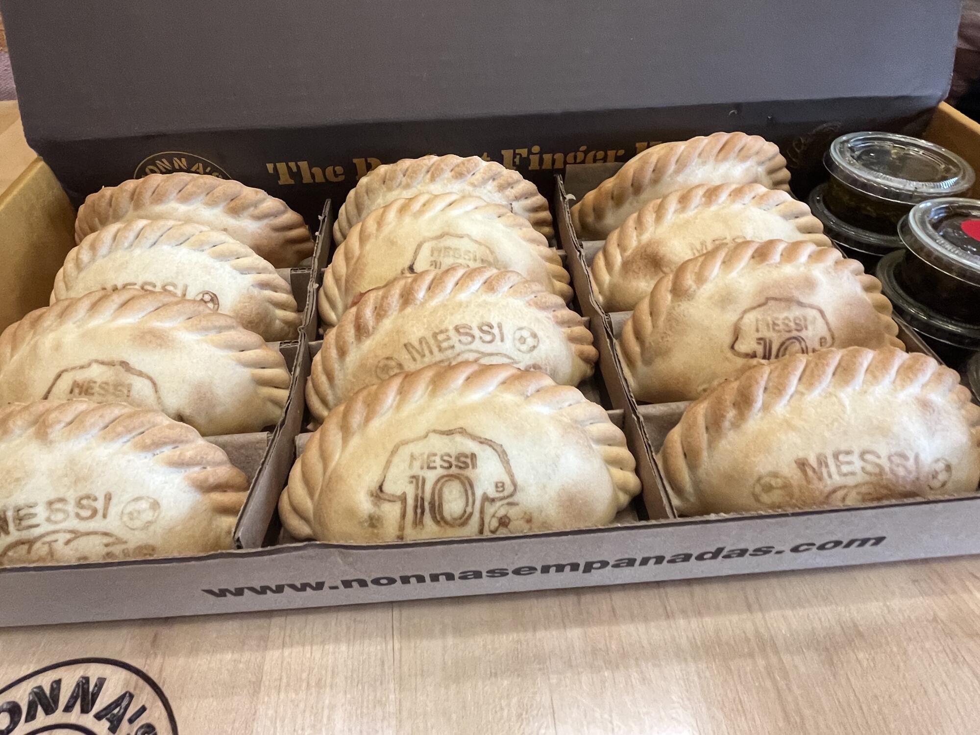 Rows of empanadas emblazoned with the name "Messi'" and images of soccer balls and No. 10 jerseys