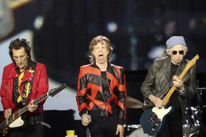 FILE - Ronnie Wood, left, Mick Jagger, center, and Keith Richards, of the Rolling Stones play on stage at the Anfield stadium in Liverpool, England, during a concert as part of their "Sixty" European tour, Thursday, June 9, 2022. The Rolling Stones canceled their concert in Amsterdam Monday just hours before it was due to start after lead singer Mick Jagger tested positive for COVID-19. The band announced the cancelation in a statement, saying the 78-year-old Jagger tested positive “after experiencing symptoms of COVID upon arrival at the stadium” on the outskirts of Amsterdam. (AP Photo/Scott Heppell, File)