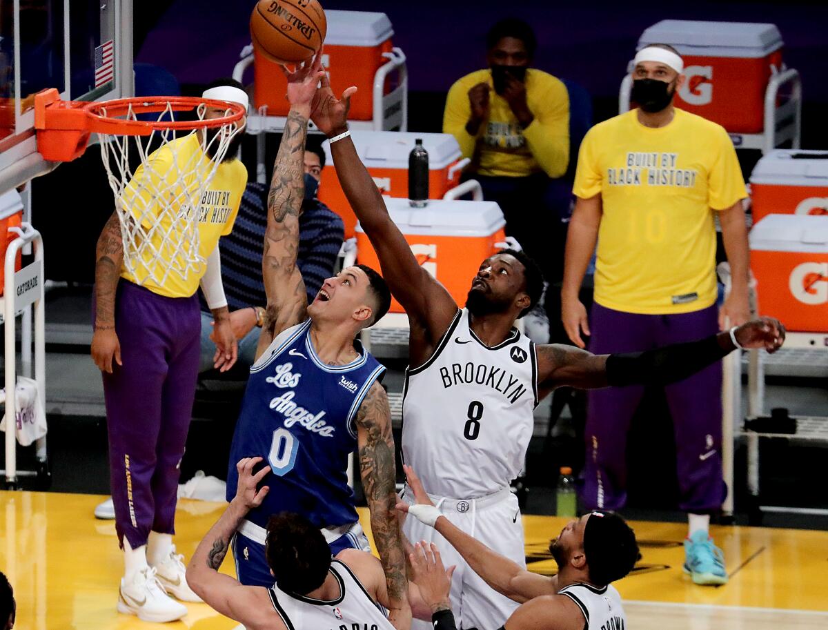 Lakers forward Kyle Kuzma fights for a rebound against Brooklyn Nets forward Jeff Green.