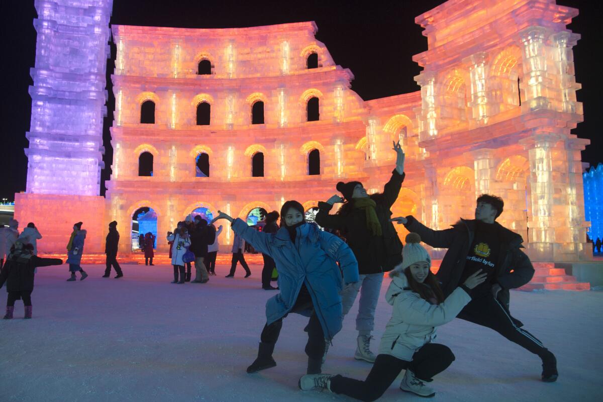 Tourists visit illuminated ice sculptures at Ice and Snow World park.