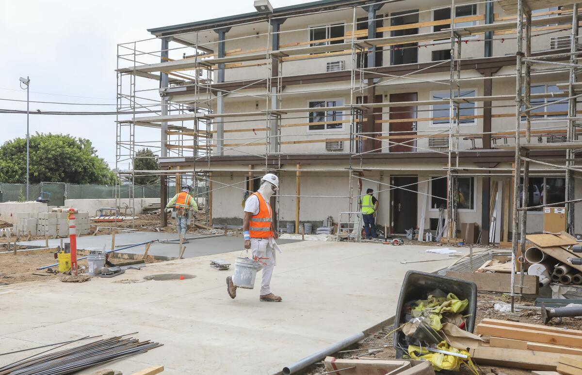 Construction crews work on an 82-unit affordable-housing project in San Diego in 2020.