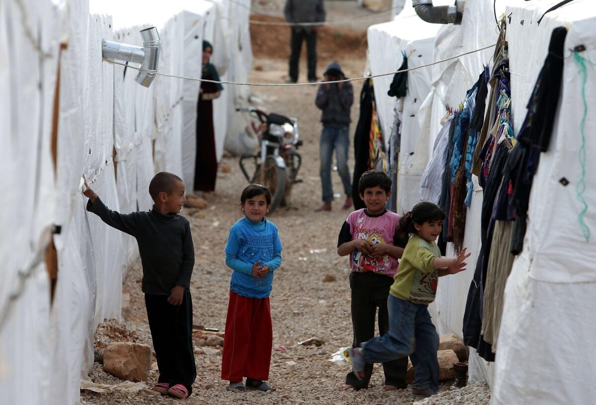 Syrian children play outside their tents at a refugee camp in the city of Arsal in Lebanon's Bekaa valley on March 28, 2014. The city has been a focal point of sectarian strife, a spillover from the civil war in Syria.