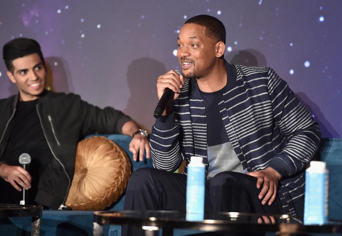 "Aladdin" star Mena Massoud, left, and Will Smith.