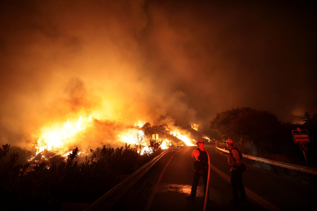 Firefighters battle the Airport fire along Ortega Highway in the Santa Ana Mountains.